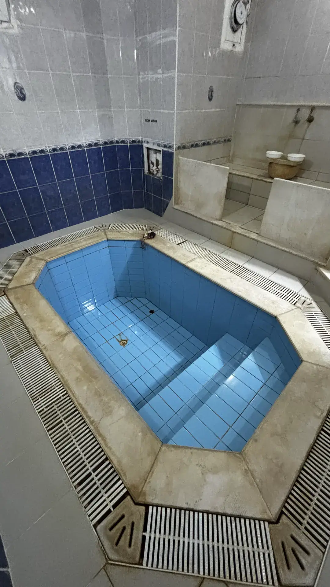 Mavi çinili özel termal havuz ve arkasında mermer kurnalı hamam sekisi