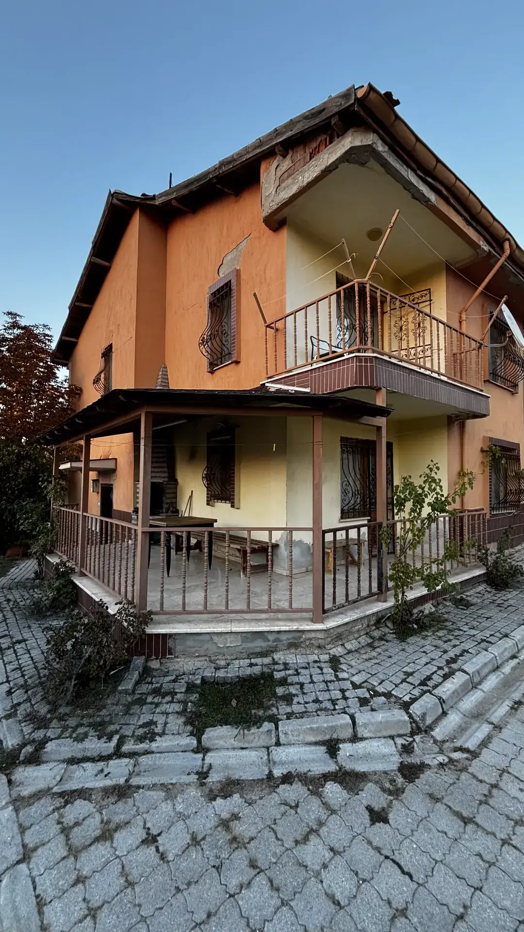 Şenol Termal Villa 50 No'lu Villa: Gazlıgöl Barbaros Termal sitesinde akşam ışığında turuncu cepheli iki katlı villa, balkonu ve korkuluklu köşe terası