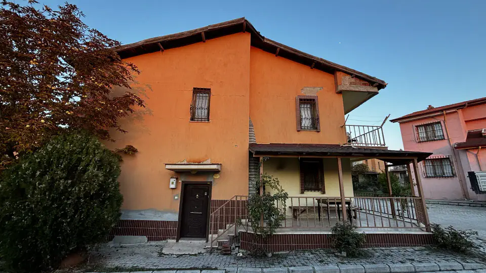 Turuncu ön cephe, giriş kapısı ve korkuluklu teras