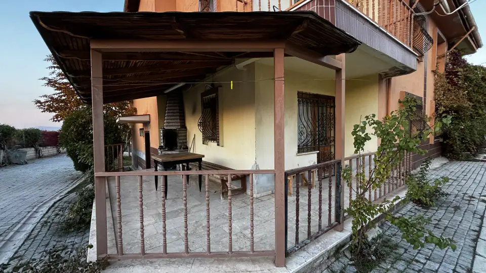 Ahşap pergolalı köşe teras, masa ve sarmaşıklar