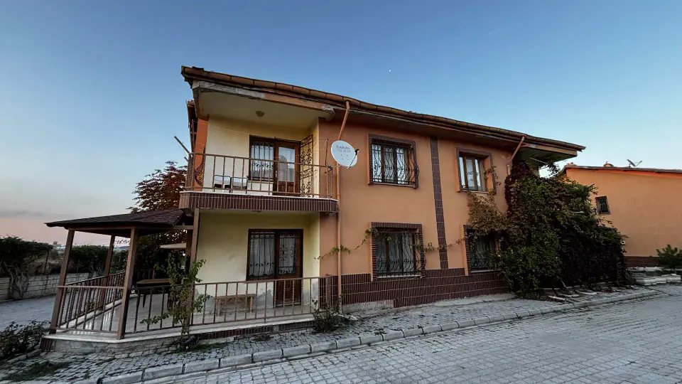 The balconied side façade and the timber-pergola terrace corner